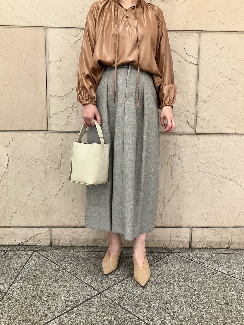 イエロー系のシャツ/ブラウス、グレー系のスカート、ホワイト系のバッグを着用したレディースの秋コーディネートの5枚目の写真