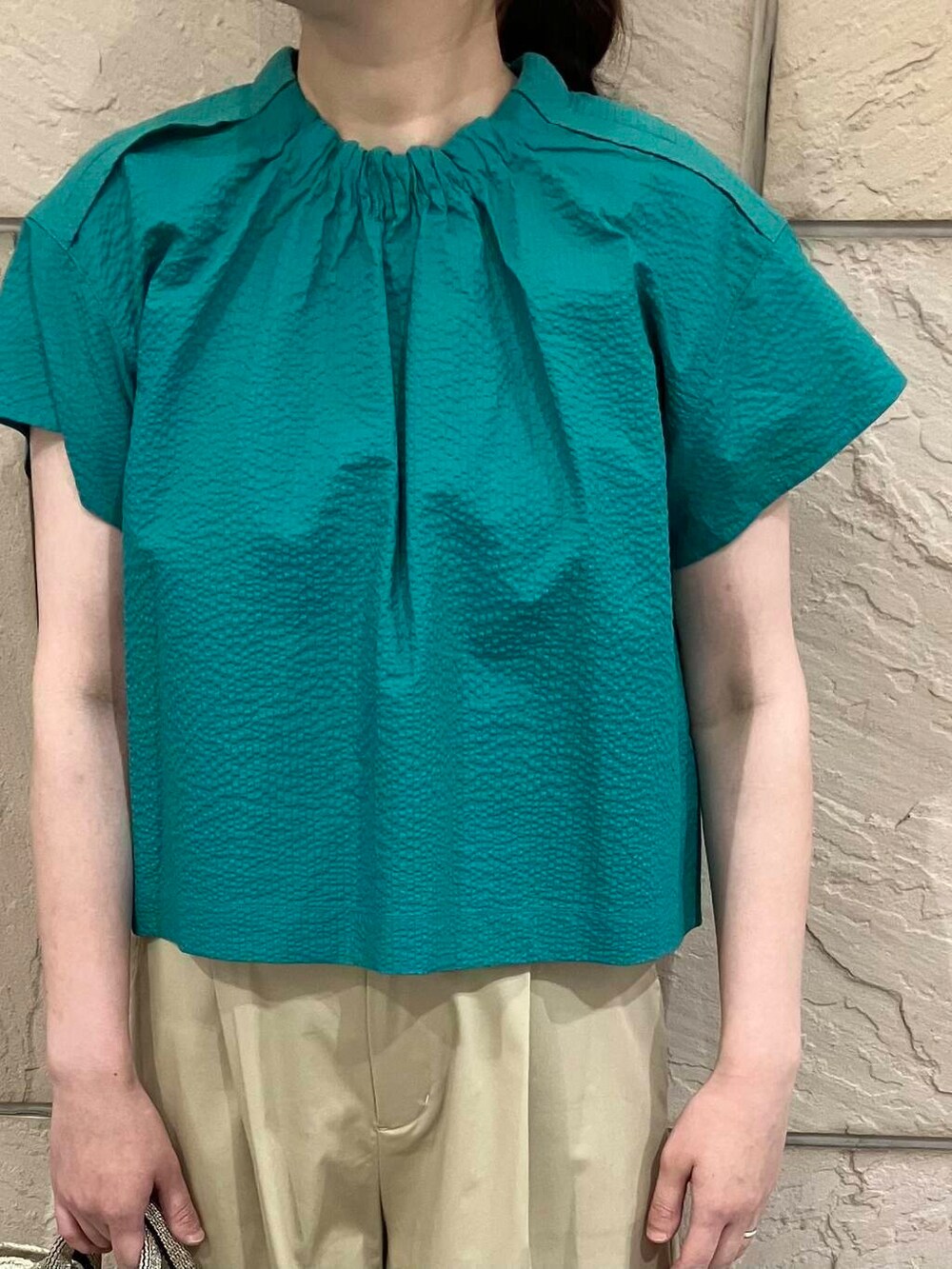 ベージュ系のかごバッグ、ベージュ系のその他パンツ、グリーン系のシャツ/ブラウスを着用したレディースの夏コーディネートの3枚目の写真