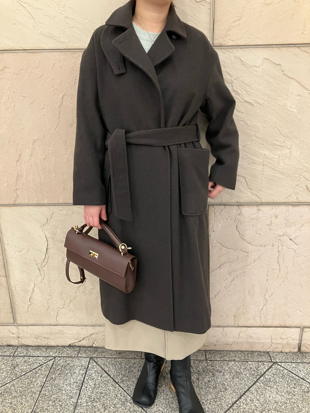 グリーン系のニット/セーター、ブラウン系のその他アウター、ベージュ系のスカートを着用したレディースの冬コーディネートの5枚目の写真