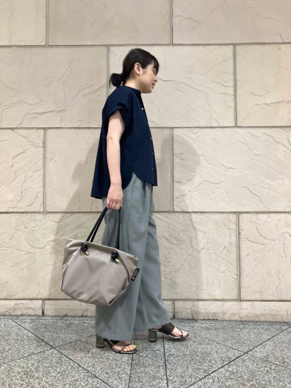 ベージュ系のトートバッグ、ブルー系のシャツ/ブラウスを着用したレディースの夏コーディネートの2枚目の写真