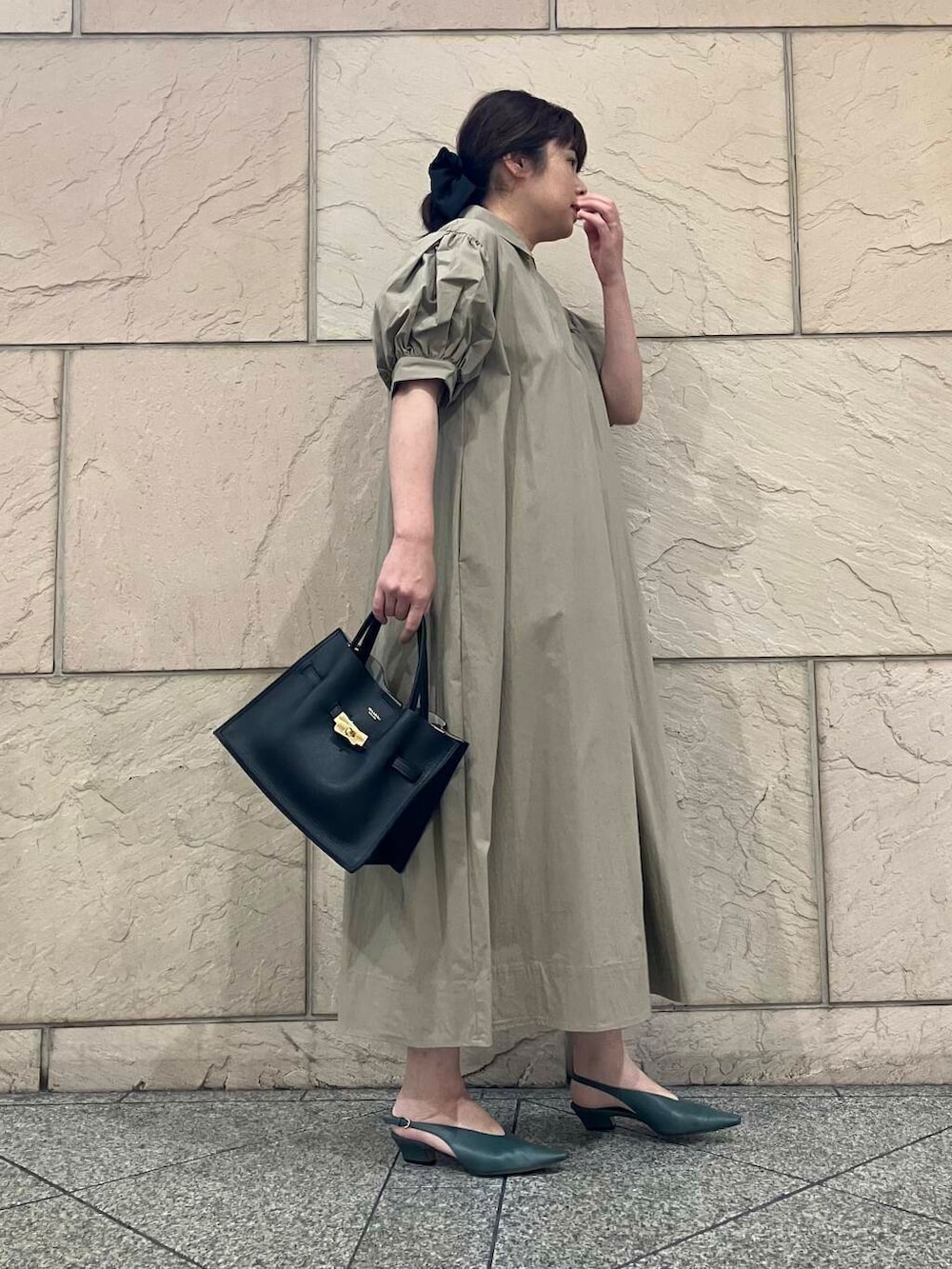ベージュ系のワンピース、ブラック系のトートバッグ、グリーン系のパンプスを着用したレディースの夏コーディネートの2枚目の写真