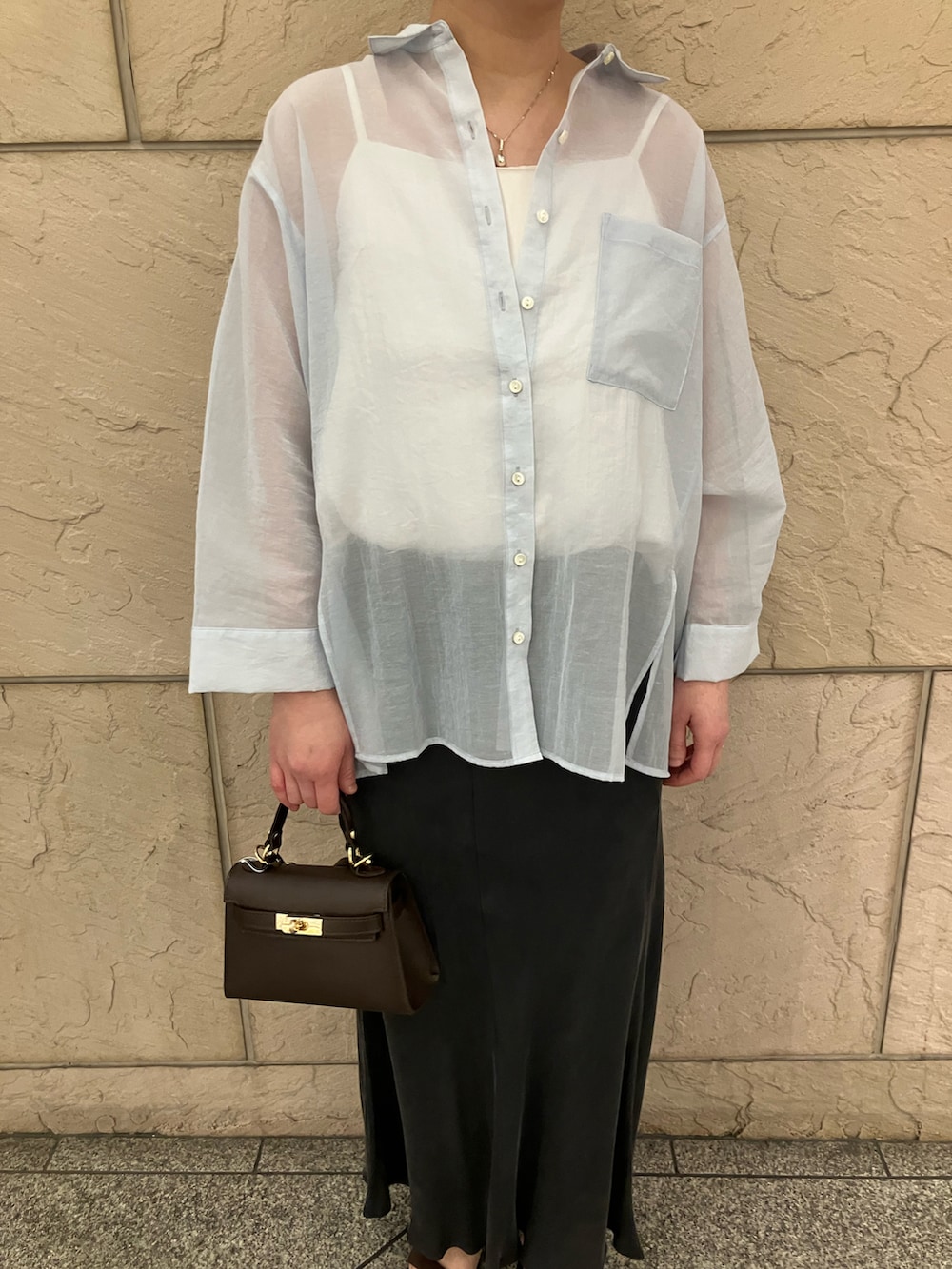 ホワイト系のキャミソール、ブラック系のスカート、ブルー系のトップスを着用したレディースの春コーディネートの4枚目の写真