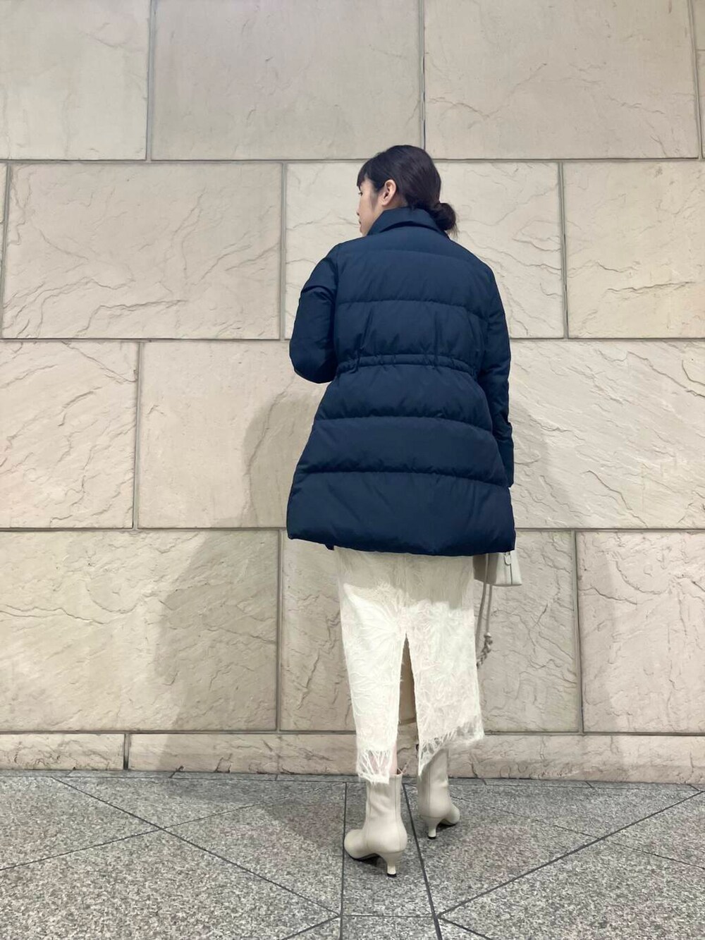 ベージュ系のブーツ、ブルー系のダウンジャケット/コート、オレンジ系のニット/セーターを着用したレディースの冬コーディネートの3枚目の写真