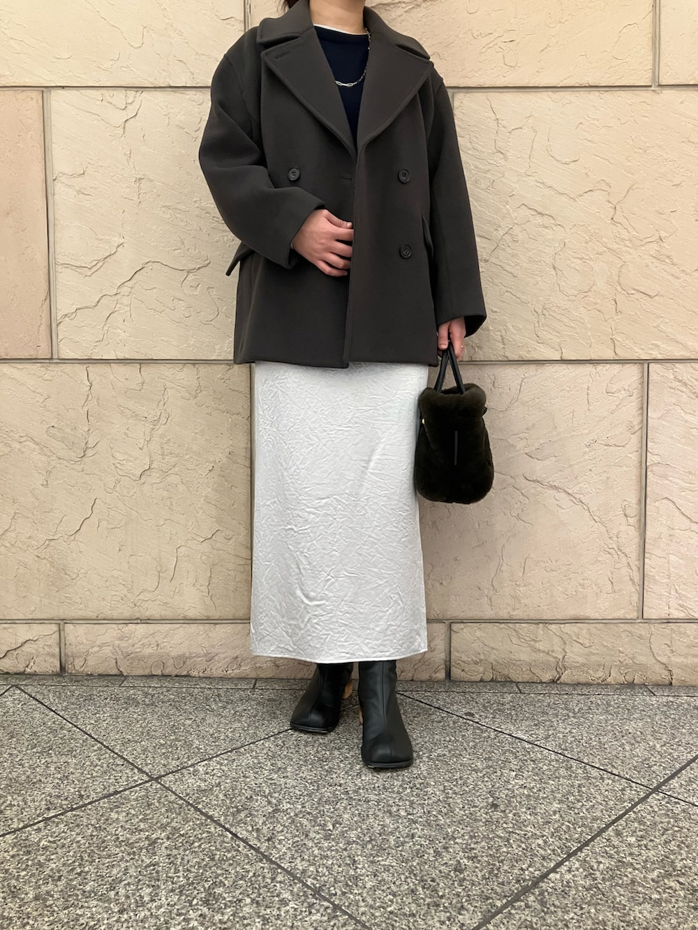 グレー系のニット/セーター、グレー系のピーコート、ブラウン系のハンドバッグを着用したレディースの秋コーディネートの5枚目の写真