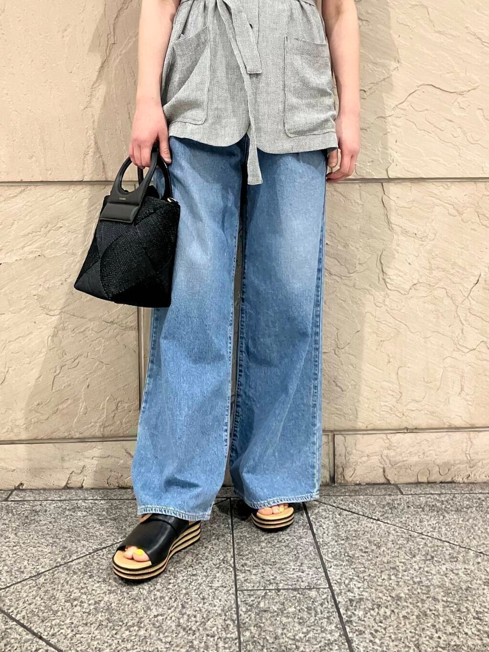 ブラック系のベスト、ブルー系のデニムパンツ、ホワイト系のTシャツ/カットソーを着用したレディースの春コーディネートの4枚目の写真