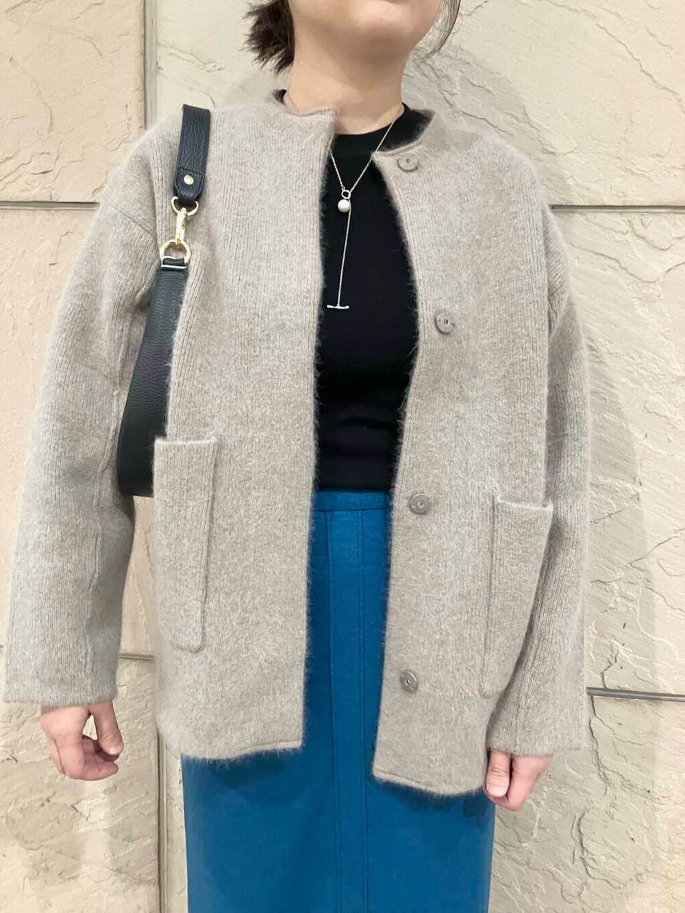 ブラック系のTシャツ/カットソー、ブラウン系のカーディガン/ボレロ、ブラック系のショルダーバッグを着用したレディースの秋コーディネートの4枚目の写真