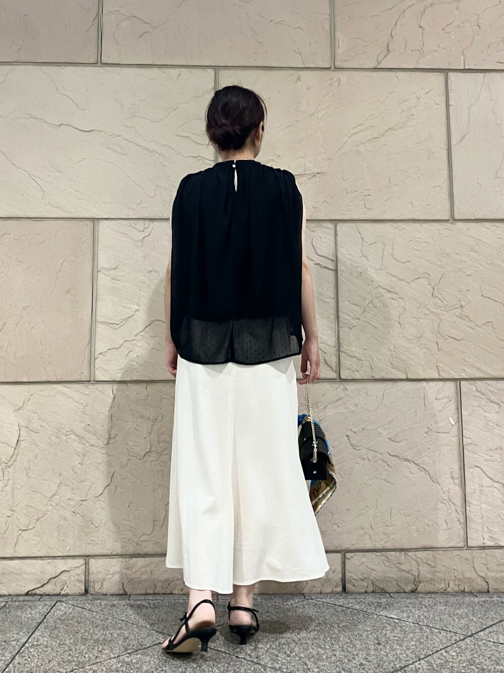ブラック系のシャツ/ブラウス、ホワイト系のスカート、ブラック系のサンダルを着用したレディースの夏コーディネートの3枚目の写真