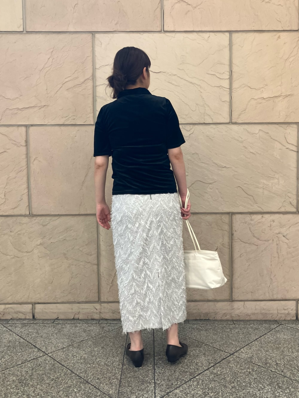 グレー系のスカート、ブラック系のTシャツ/カットソー、ホワイト系のトートバッグを着用したレディースの夏コーディネートの3枚目の写真