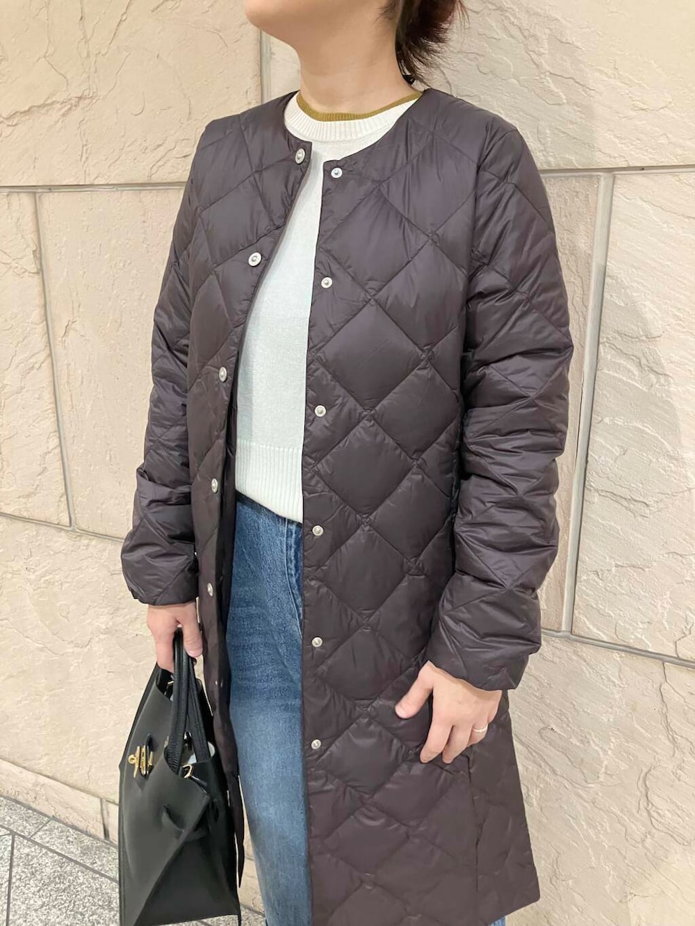 ブルー系のデニムパンツ、ホワイト系のニット/セーター、ブラック系のパンプスを着用したレディースの秋コーディネートの4枚目の写真