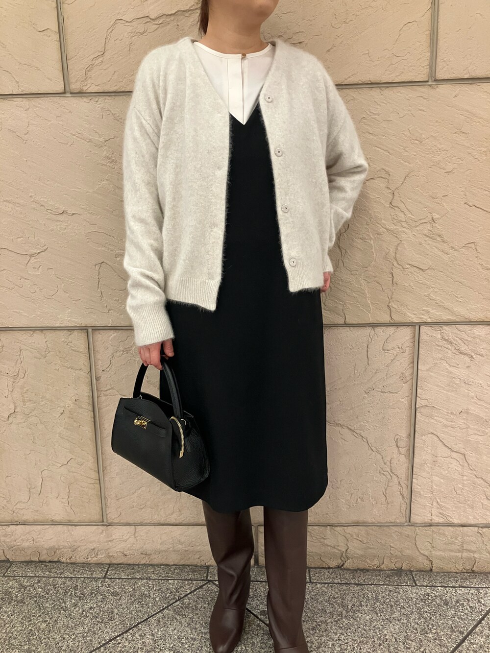 ブラック系のワンピース、ホワイト系のカーディガン/ボレロ、ホワイト系のシャツ/ブラウスを着用したレディースの冬コーディネートの5枚目の写真