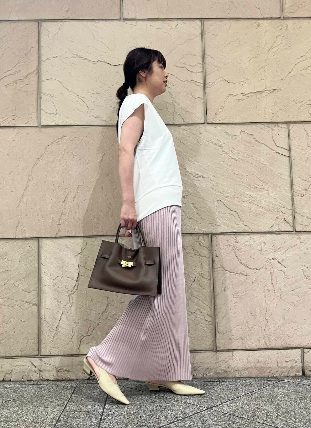 ホワイト系のスウェット、ピンク系のスカート、ベージュ系のパンプスを着用したレディースの夏コーディネートの2枚目の写真