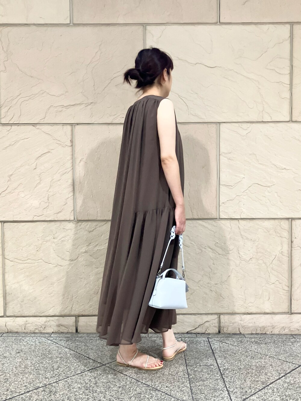 ブラウン系のワンピース、ブルー系のショルダーバッグ、シルバー系のサンダルを着用したレディースの夏コーディネートの2枚目の写真