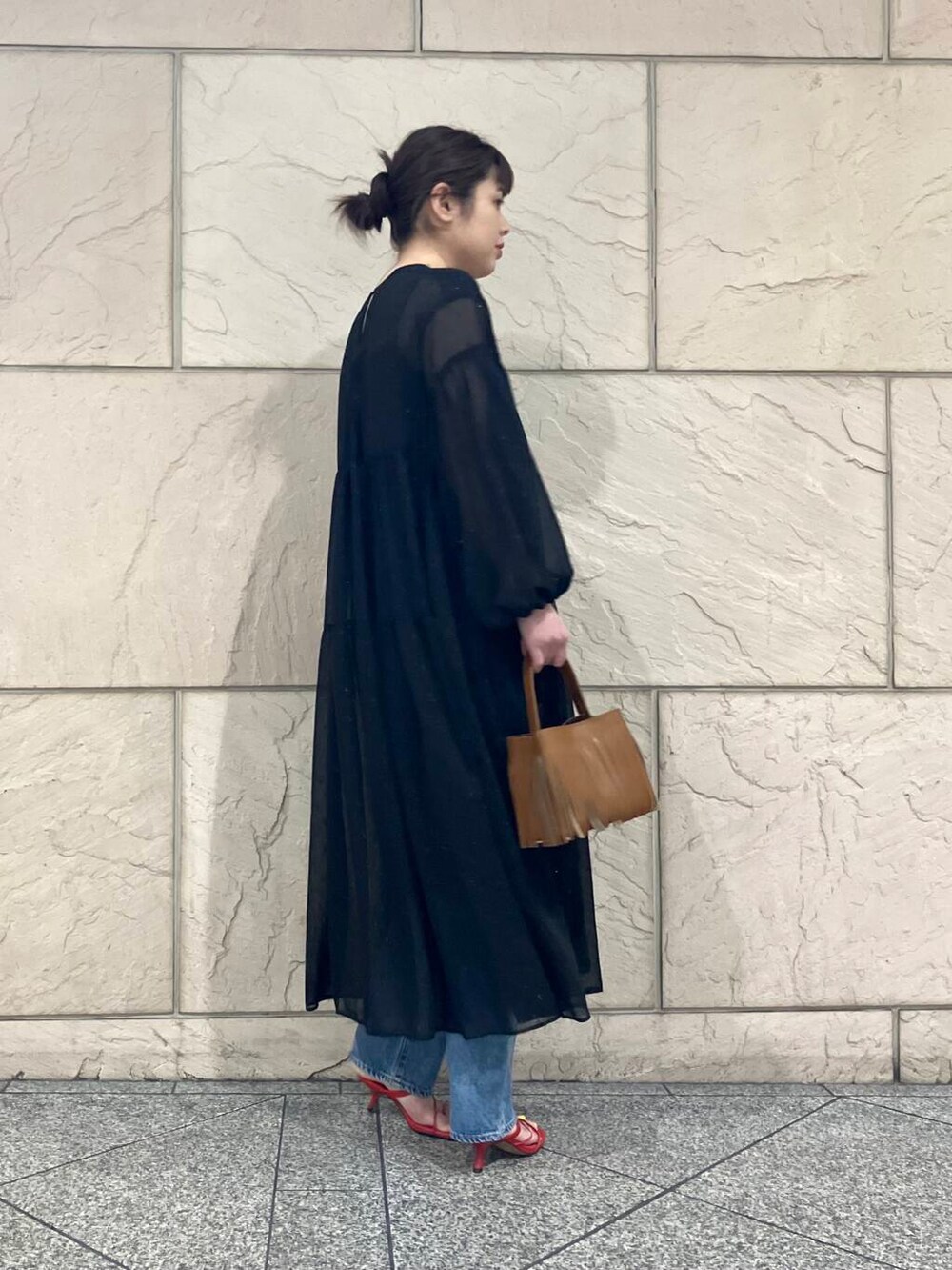 ブラック系のワンピース、イエロー系のハンドバッグを着用したレディースの春コーディネートの3枚目の写真