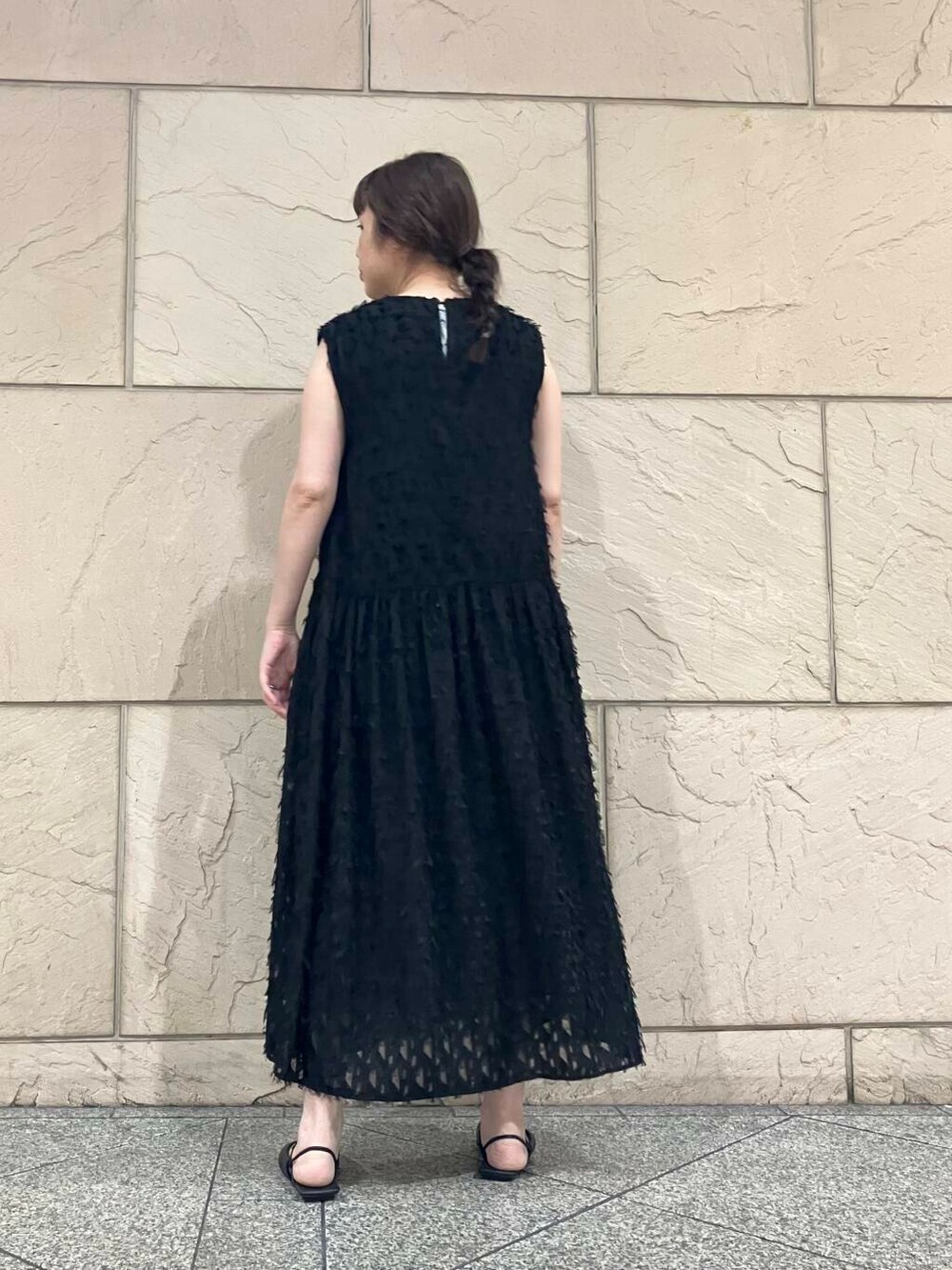 シルバー系のハンドバッグ、ブラック系のワンピース、その他のメガネを着用したレディースの夏コーディネートの2枚目の写真