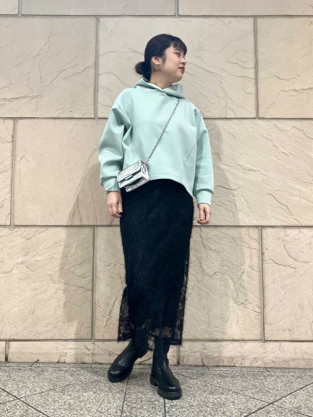 ブラック系のブーツ、シルバー系のショルダーバッグ、ブラック系のスカートを着用したレディースの冬コーディネートの5枚目の写真