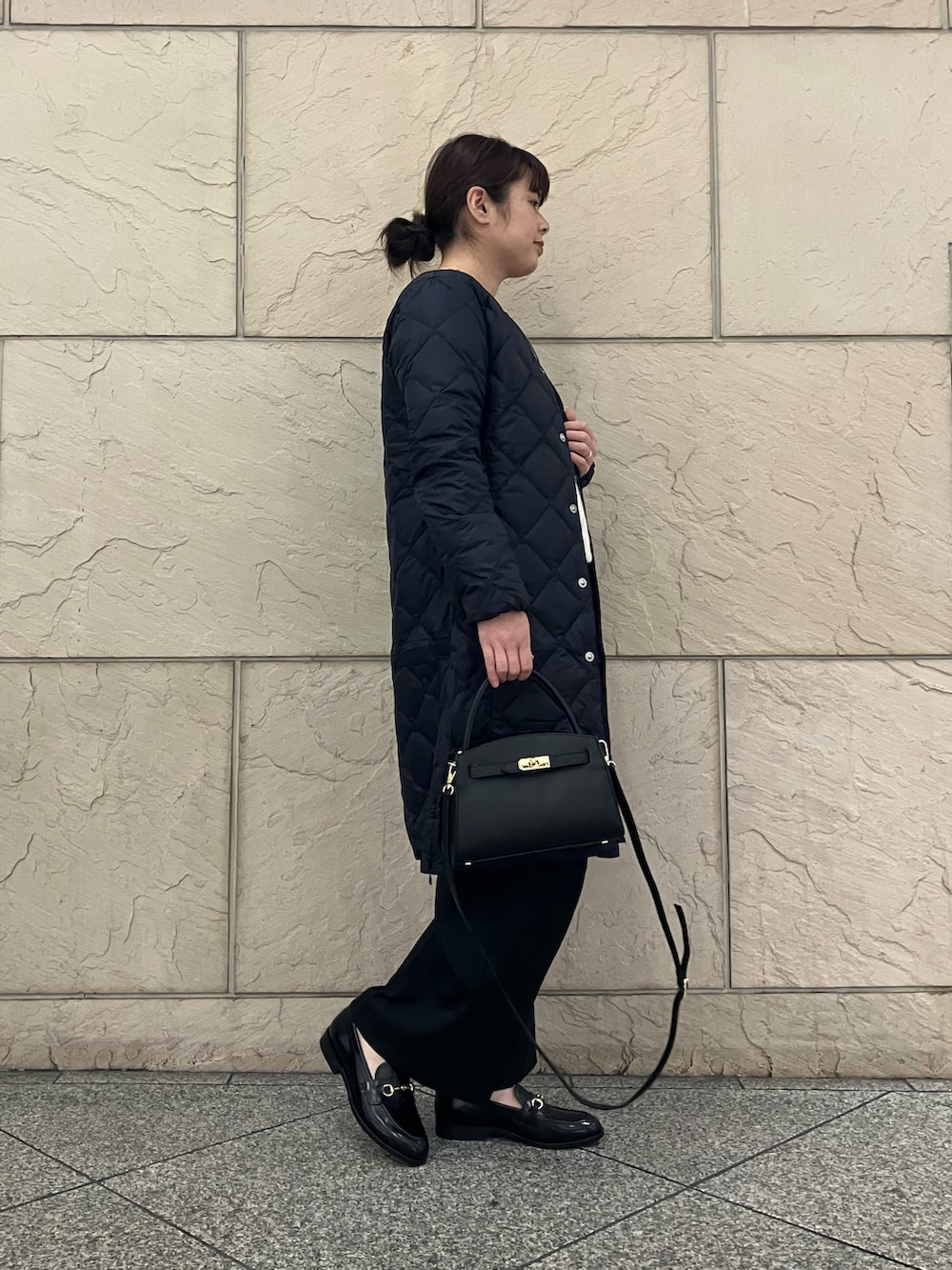 ホワイト系のカーディガン/ボレロ、ブラック系のパンツ、ブラック系のバッグを着用したレディースの秋コーディネートの2枚目の写真