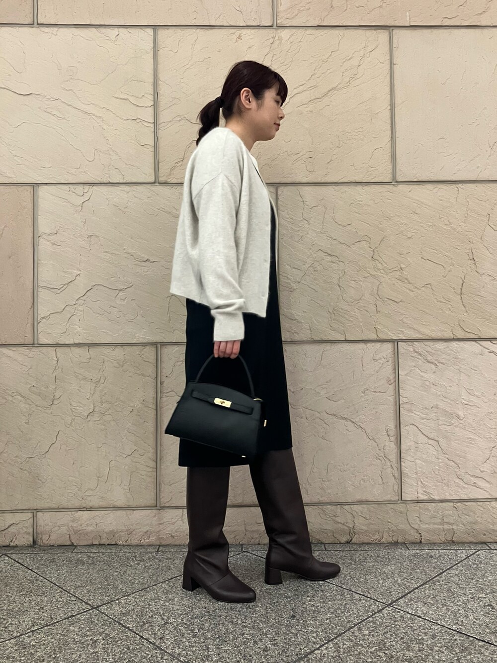 ブラック系のワンピース、ホワイト系のカーディガン/ボレロ、ホワイト系のシャツ/ブラウスを着用したレディースの冬コーディネートの2枚目の写真