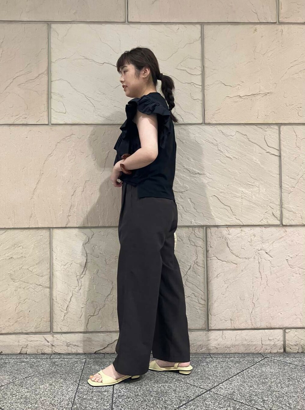 ベージュ系のかごバッグ、イエロー系のサンダル、ブラック系のTシャツ/カットソーを着用したレディースの夏コーディネートの3枚目の写真