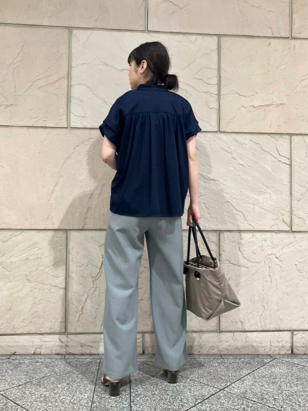 ベージュ系のトートバッグ、ブルー系のシャツ/ブラウスを着用したレディースの夏コーディネートの3枚目の写真