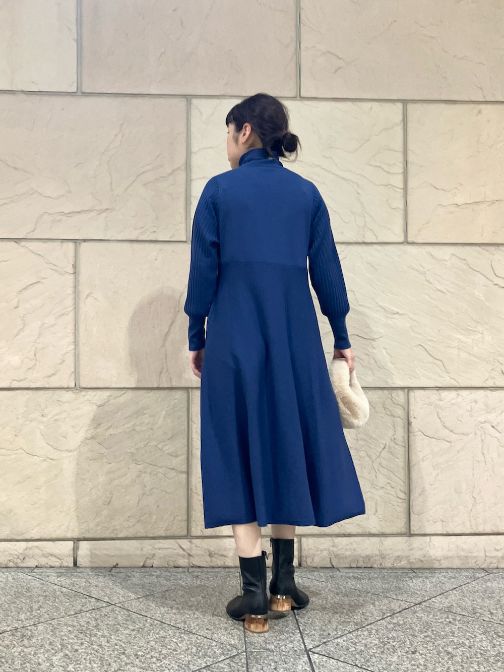 ブルー系のワンピース、ブラック系のブーツ、シルバー系のネックレスを着用したレディースの秋コーディネートの3枚目の写真