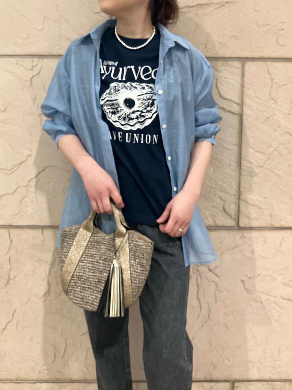 ゴールド系のかごバッグ、ブルー系のシャツ/ブラウス、ブルー系のTシャツ/カットソーを着用したレディースの春コーディネートの8枚目の写真