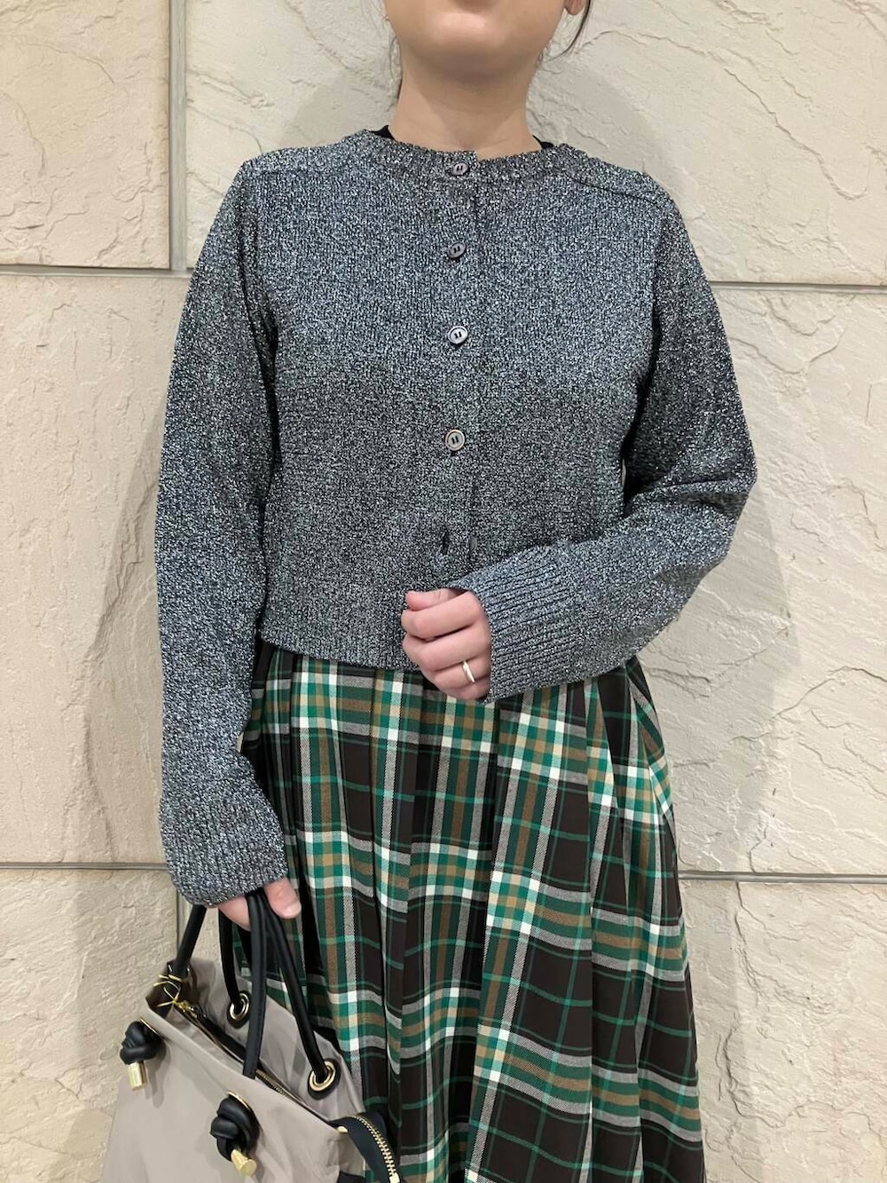 ベージュ系のハンドバッグ、ブラック系のニット/セーター、グリーン系のスカートを着用したレディースの秋コーディネートの3枚目の写真