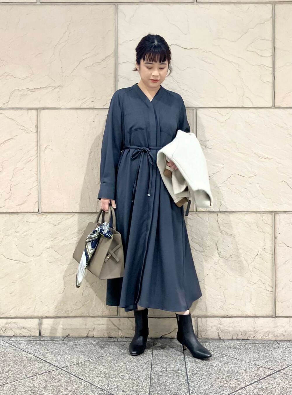 グレー系のワンピース、グレー系のカーディガン/ボレロ、ブラック系のブーツを着用したレディースの秋コーディネートの5枚目の写真