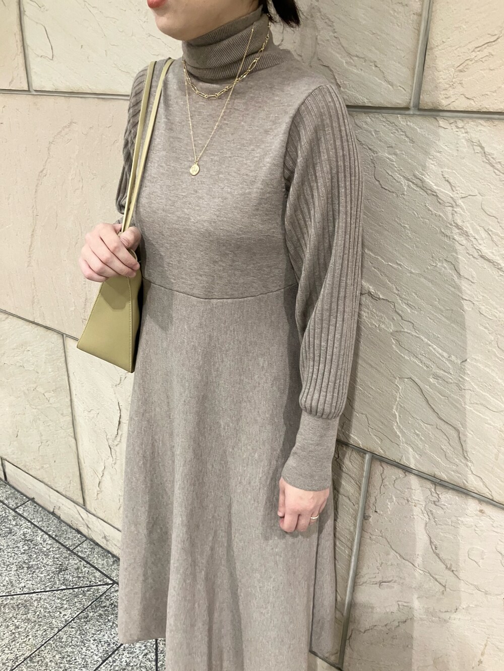 ベージュ系のワンピース、ホワイト系のブーツ、ゴールド系のネックレスを着用したレディースの秋コーディネートの5枚目の写真