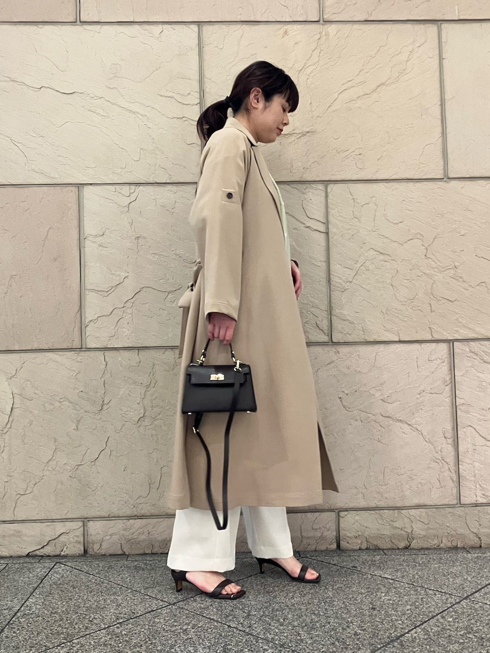 ベージュ系のトレンチコート、ホワイト系のその他パンツ、イエロー系のシャツ/ブラウスを着用したレディースの春コーディネートの2枚目の写真