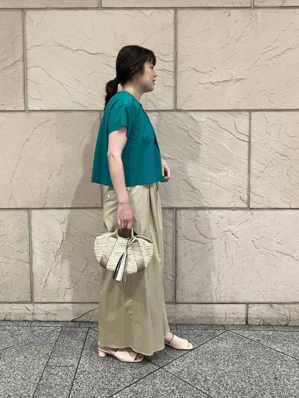 ベージュ系のかごバッグ、ベージュ系のその他パンツ、グリーン系のシャツ/ブラウスを着用したレディースの夏コーディネートの2枚目の写真