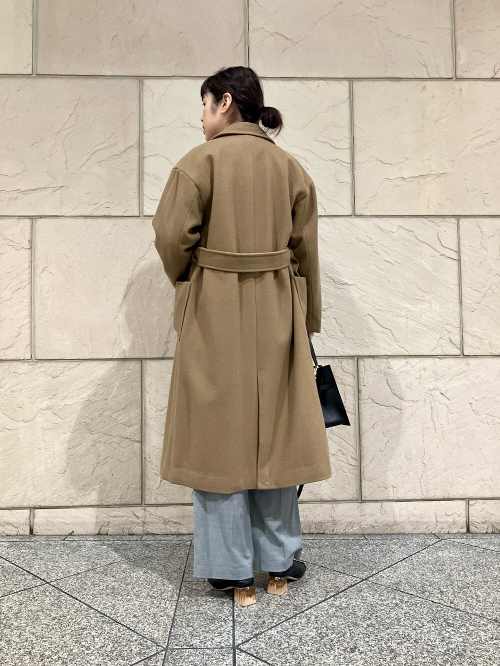 レッド系のニット/セーター、ベージュ系のその他アウター、グレー系のパンツを着用したレディースの秋コーディネートの5枚目の写真