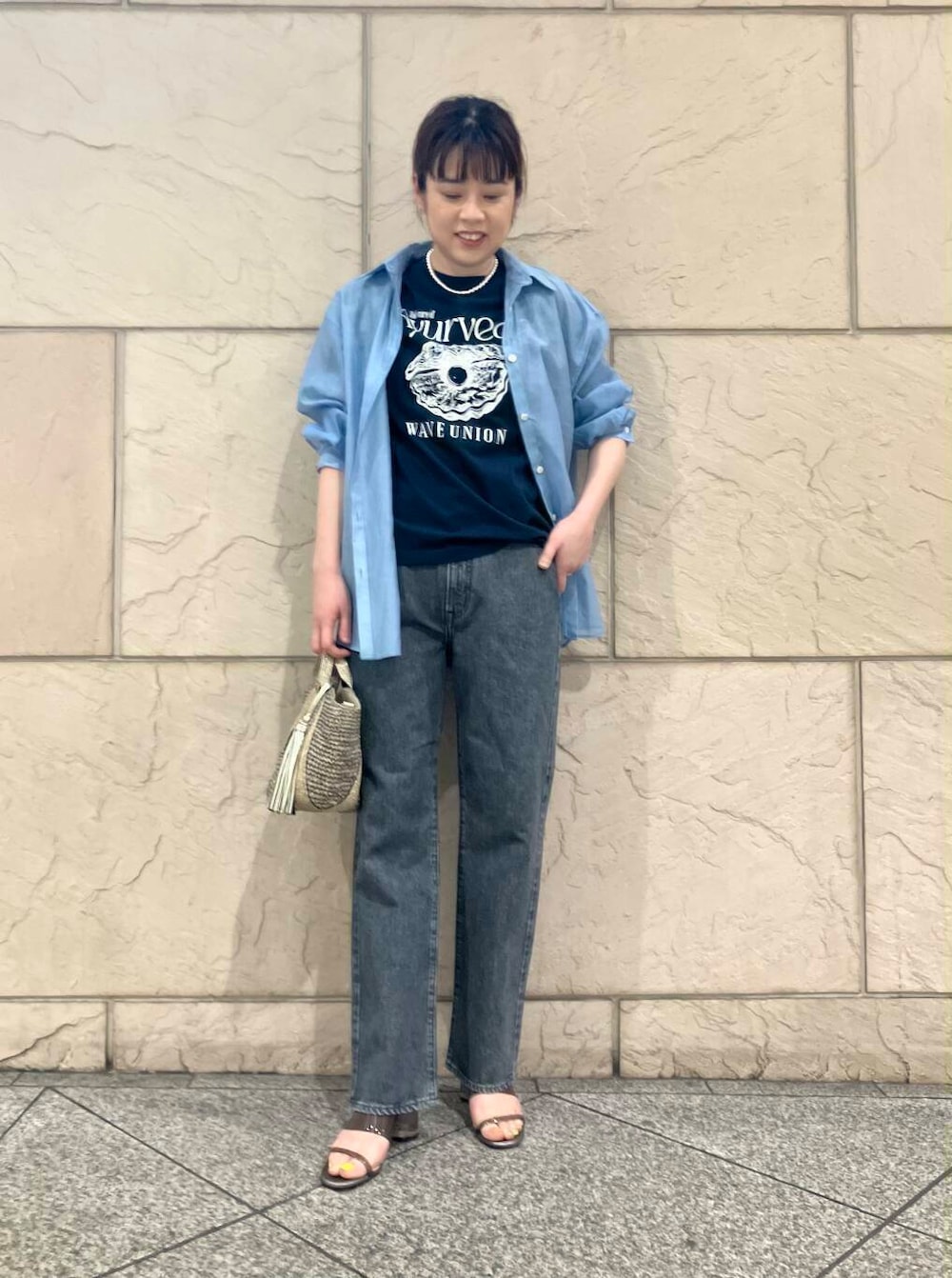 ゴールド系のかごバッグ、ブルー系のシャツ/ブラウス、ブルー系のTシャツ/カットソーを着用したレディースの春コーディネートの6枚目の写真