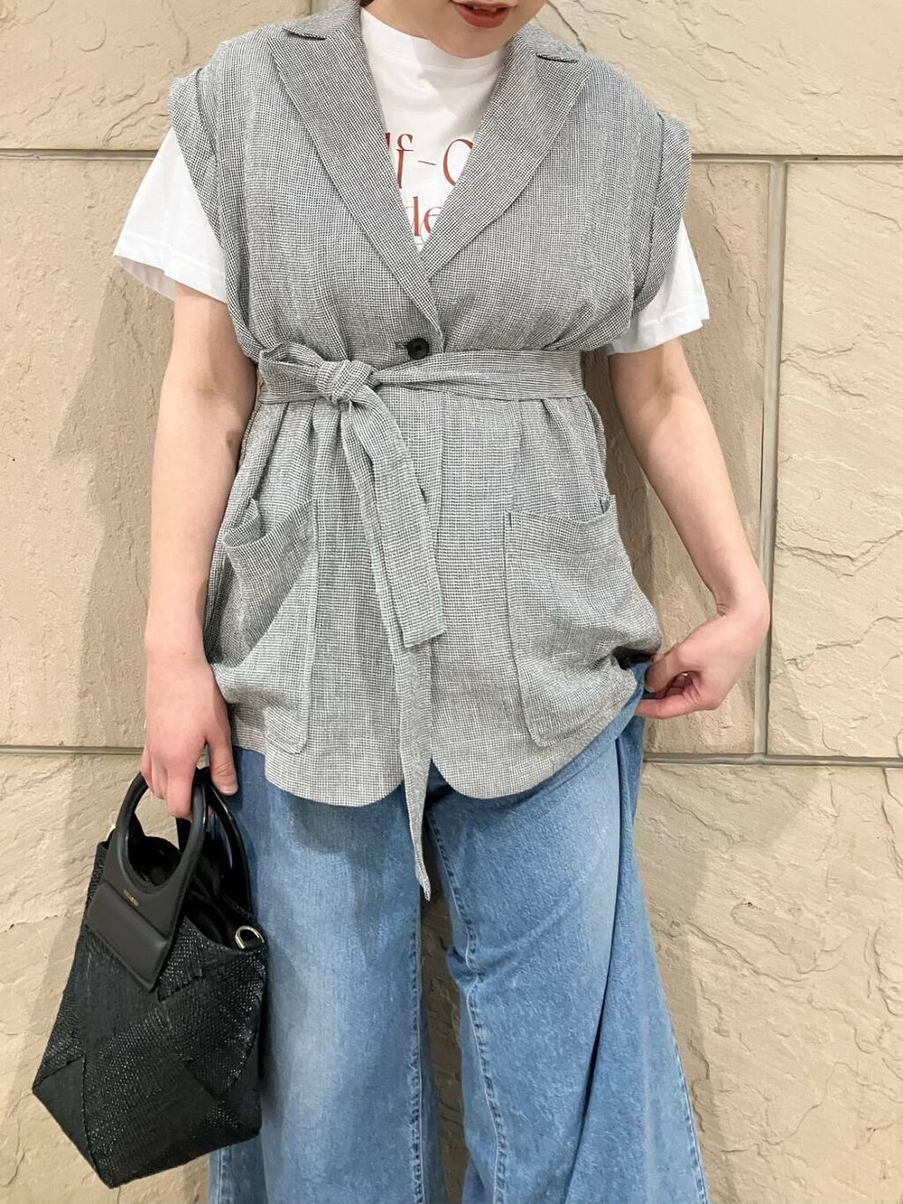 ブラック系のベスト、ブルー系のデニムパンツ、ホワイト系のTシャツ/カットソーを着用したレディースの春コーディネートの3枚目の写真