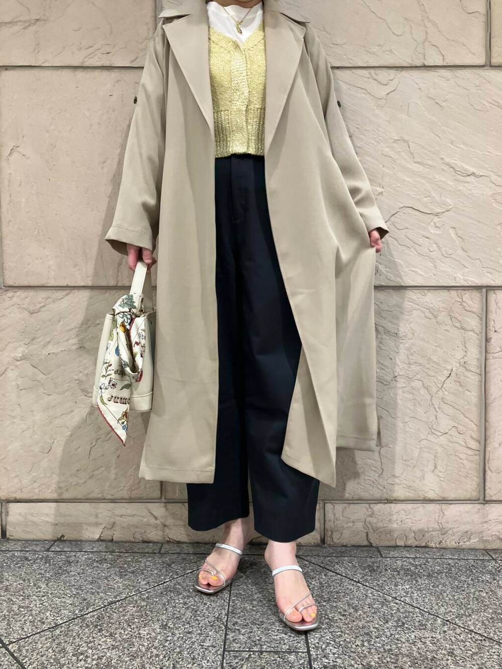 ベージュ系のトレンチコート、イエロー系のカーディガン/ボレロ、グレー系のその他パンツを着用したレディースの冬コーディネートの5枚目の写真