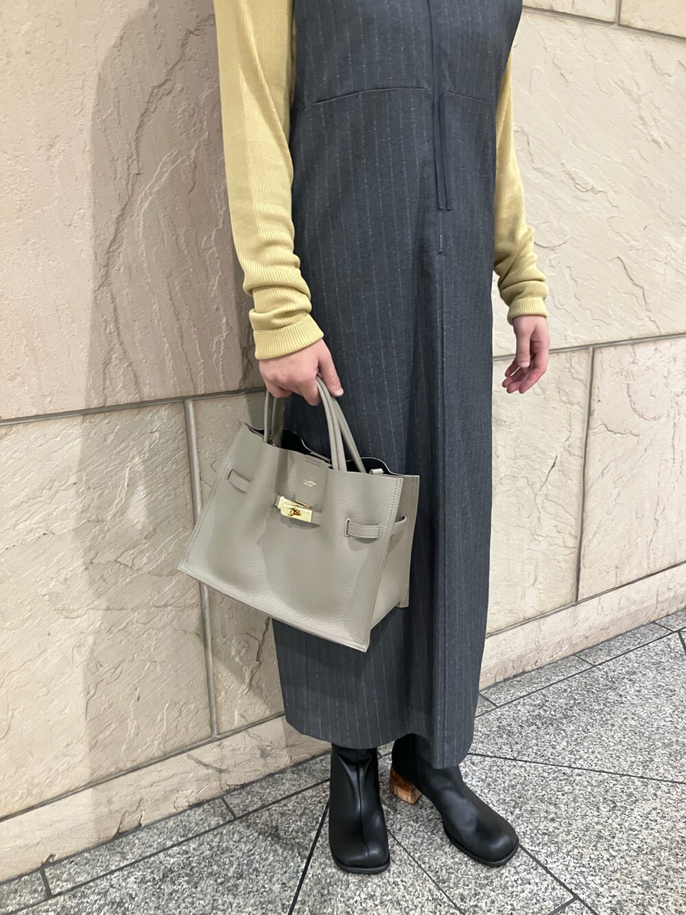 グレー系のワンピース、イエロー系のニット/セーター、ベージュ系のトートバッグを着用したレディースの秋コーディネートの5枚目の写真