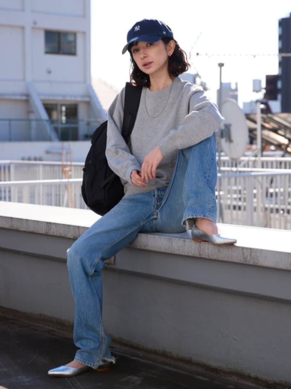 ブルー系のデニムパンツ、グレー系のスウェットを着用したレディースの春コーディネートの2枚目の写真