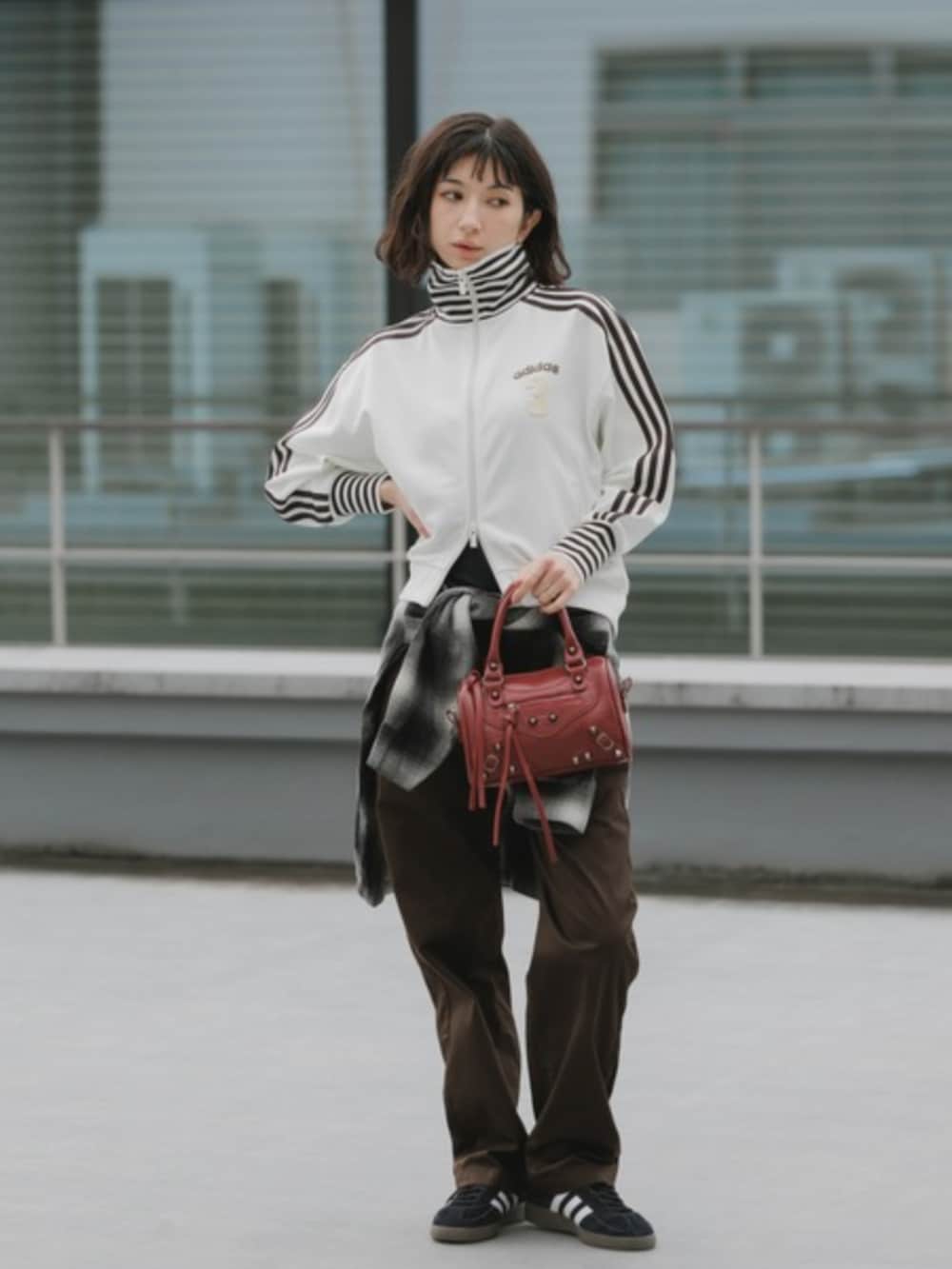 レッド系のショルダーバッグ、ホワイト系のジャージ、ブラック系のシャツ/ブラウスを着用したレディースの春コーディネートの2枚目の写真