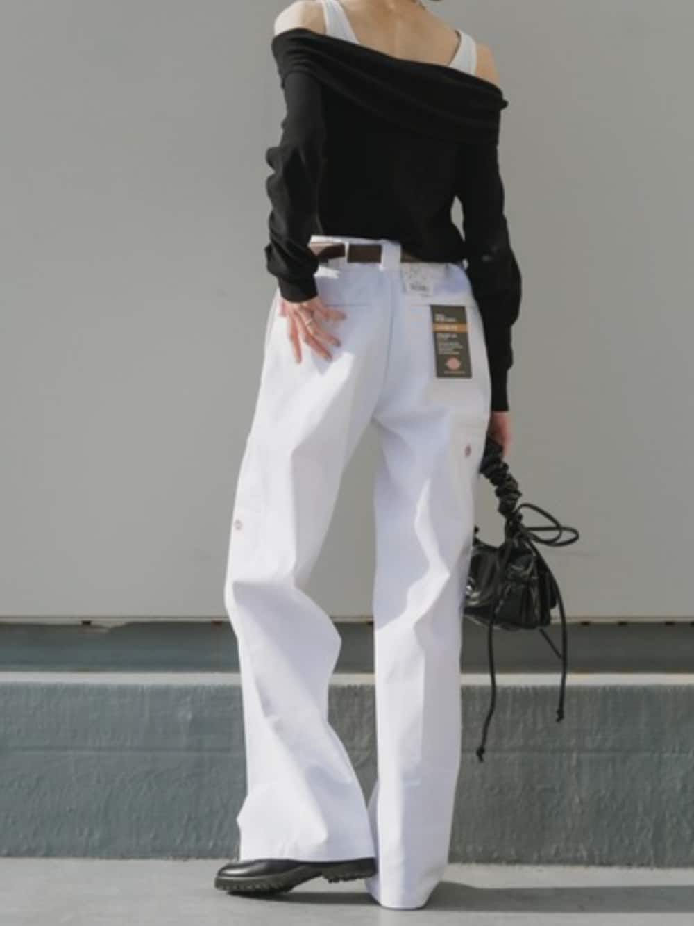 シルバー系のハンドバッグ、ホワイト系のチノパンツ、ブラック系のTシャツ/カットソーを着用したレディースの春コーディネートの3枚目の写真