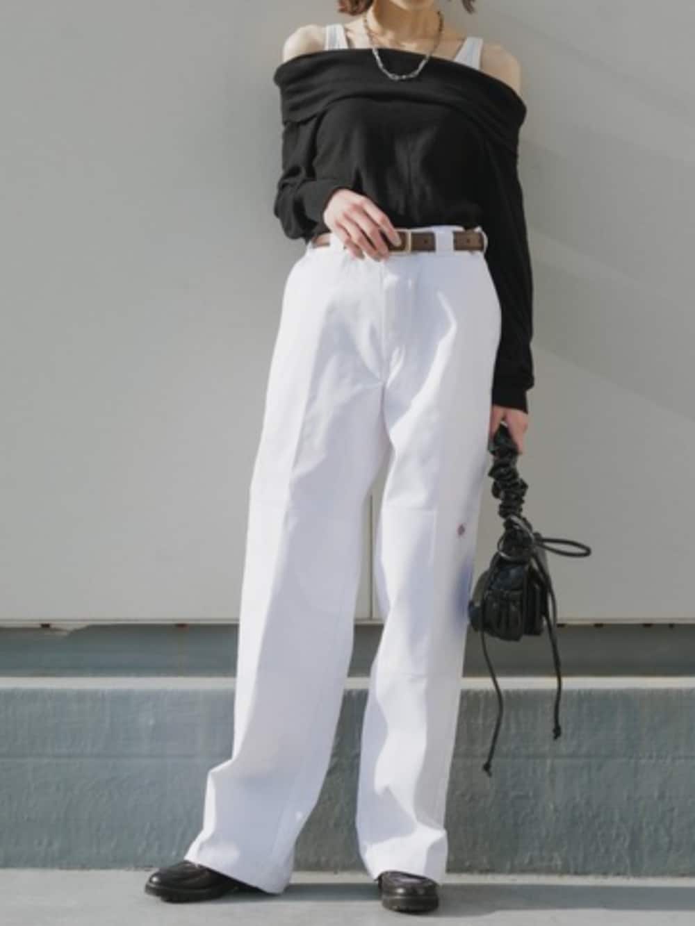 シルバー系のハンドバッグ、ホワイト系のチノパンツ、ブラック系のTシャツ/カットソーを着用したレディースの春コーディネートの2枚目の写真