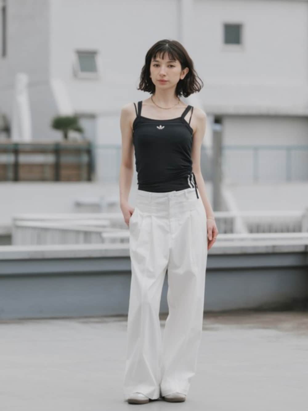 ブラック系のタンクトップ、ホワイト系のスラックスを着用したレディースの春コーディネートの3枚目の写真