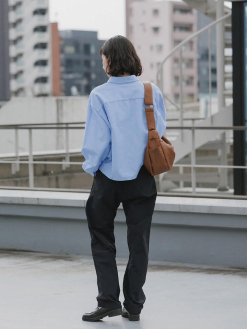 ブラック系のその他パンツ、ブルー系のシャツ/ブラウスを着用したレディースの春コーディネートの2枚目の写真