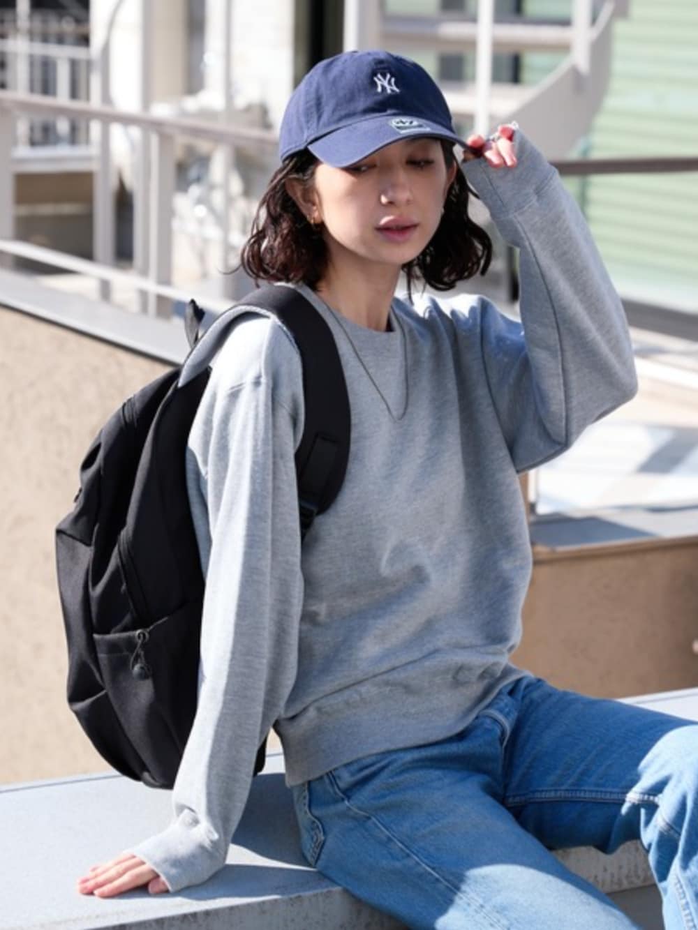 ブルー系のデニムパンツ、グレー系のスウェットを着用したレディースの春コーディネートの2枚目の写真