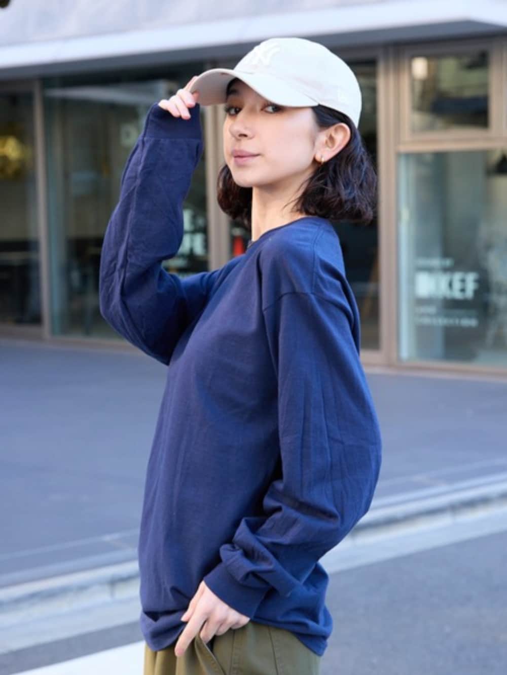 ブラック系のスニーカー、ブルー系のTシャツ/カットソー、グリーン系のカーゴパンツを着用したレディースの春コーディネートの4枚目の写真