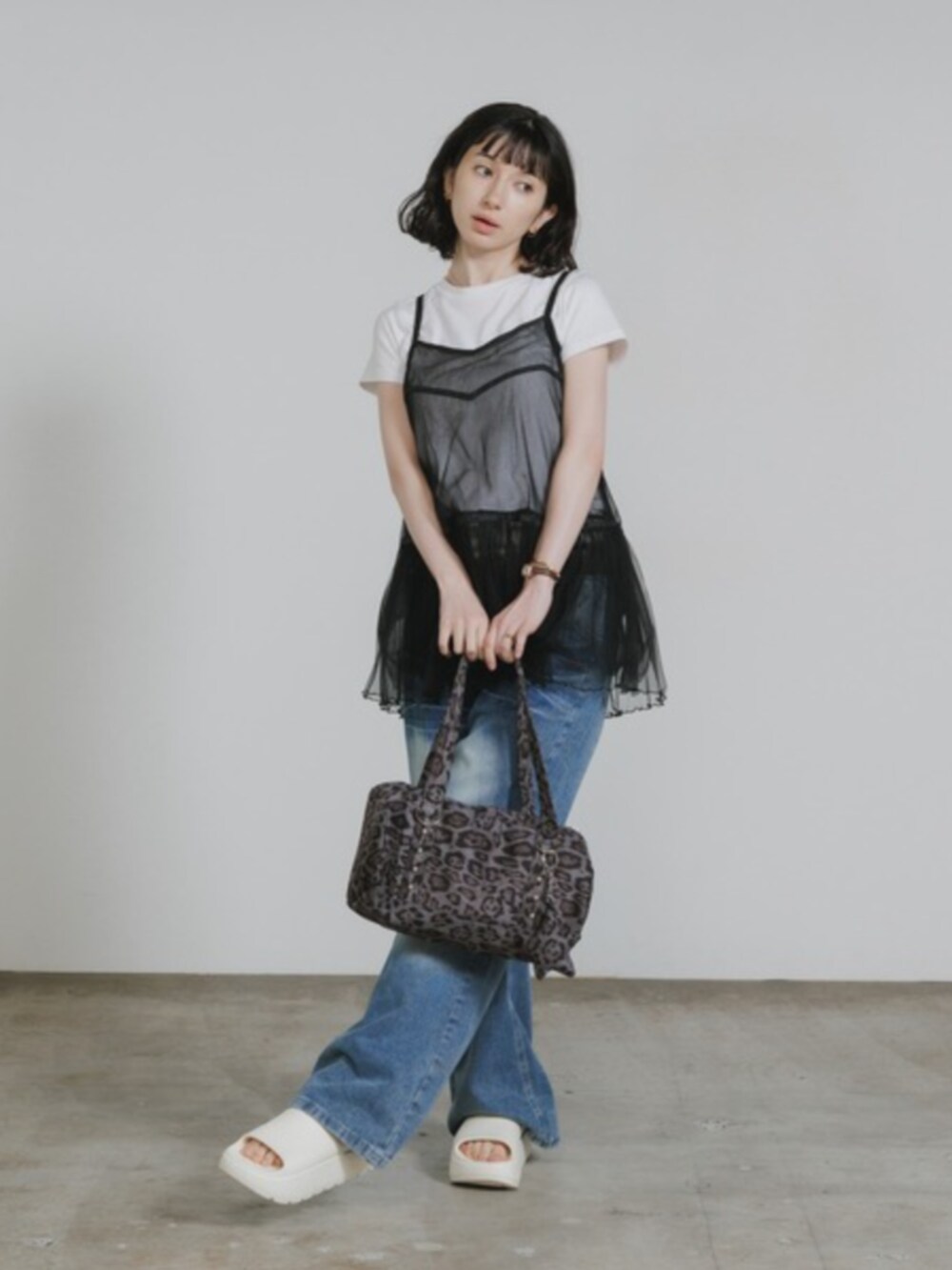ブルー系のデニムパンツ、ブラック系のワンピース、ホワイト系のTシャツ/カットソーを着用したレディースの春コーディネートの3枚目の写真