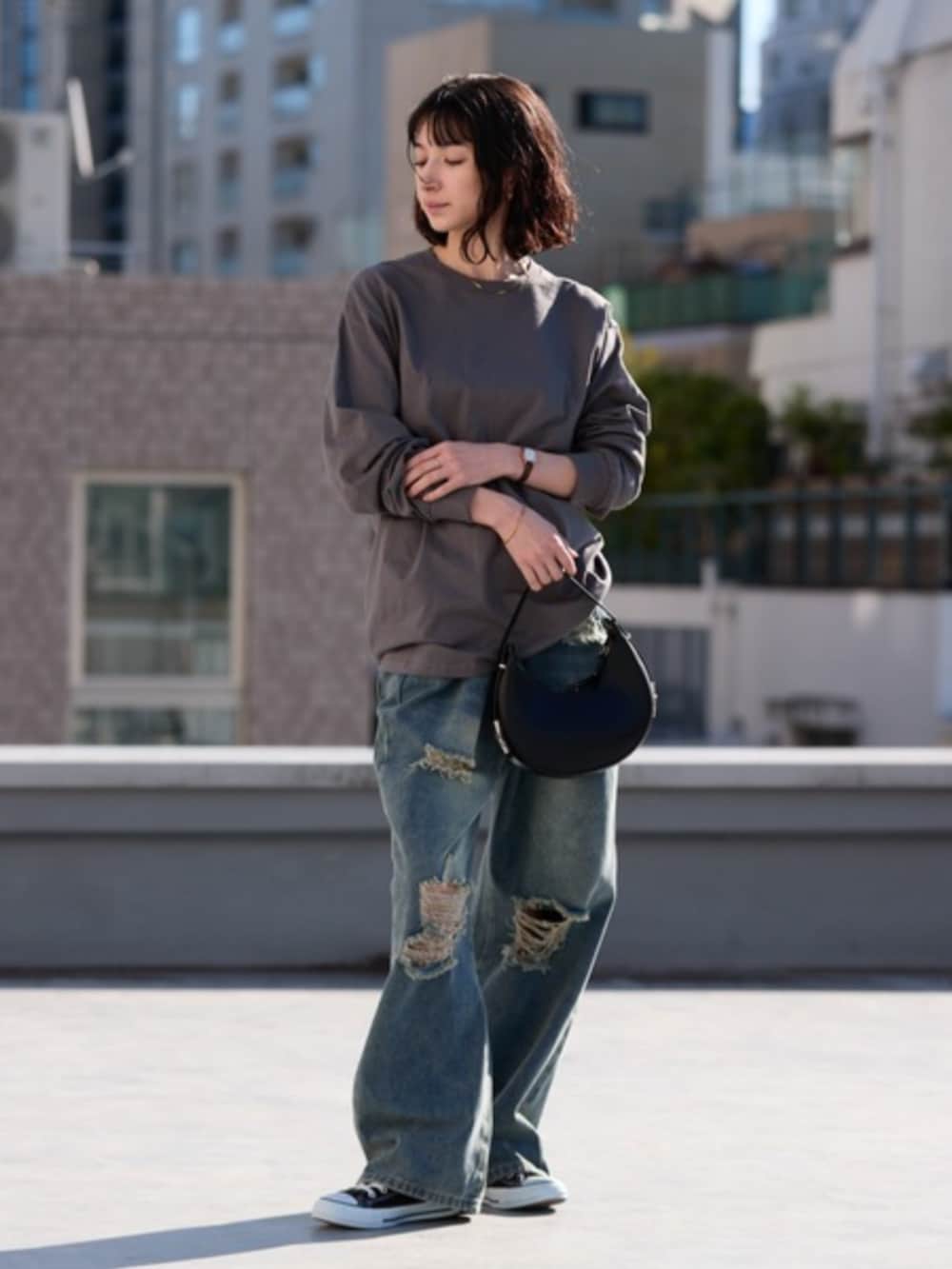 グレー系のTシャツ/カットソー、ブルー系のデニムパンツを着用したレディースの春コーディネートの3枚目の写真