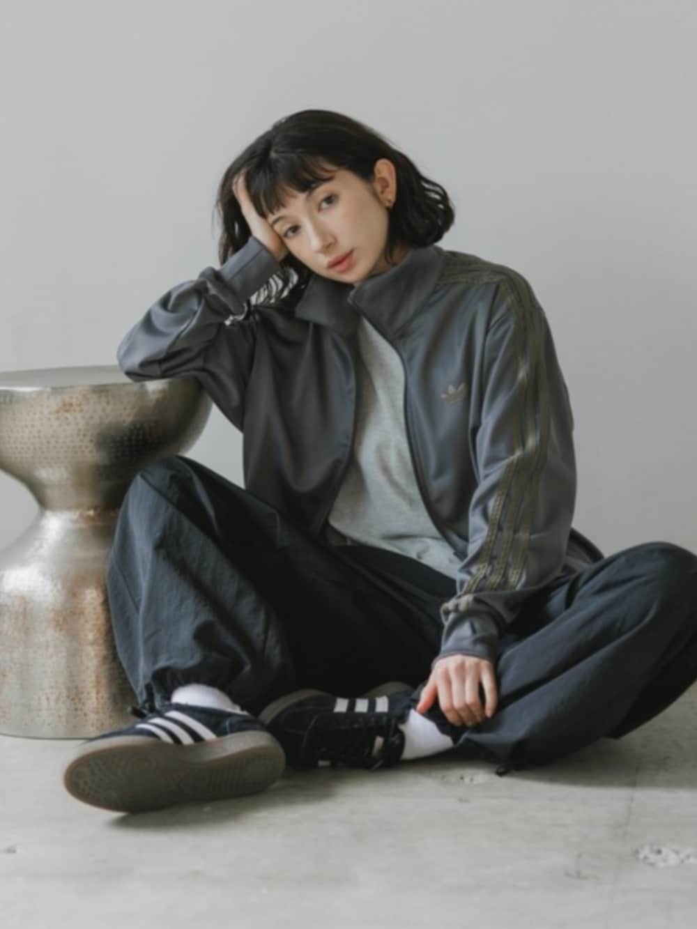 ブラック系のデニムパンツ、グレー系のジャージを着用したレディースの春コーディネートの2枚目の写真