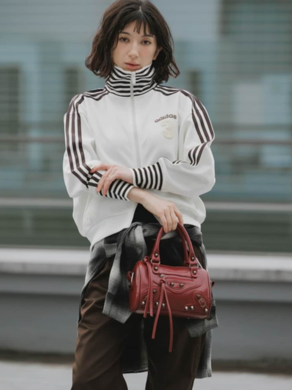 レッド系のショルダーバッグ、ホワイト系のジャージ、ブラック系のシャツ/ブラウスを着用したレディースの春コーディネートの3枚目の写真