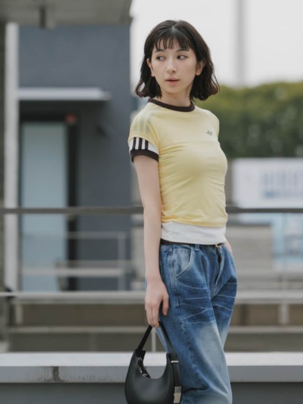 ブルー系のデニムパンツ、イエロー系のTシャツ/カットソーを着用したレディースの春コーディネートの3枚目の写真
