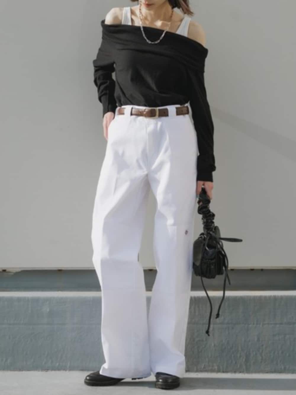 シルバー系のハンドバッグ、ホワイト系のチノパンツ、ブラック系のTシャツ/カットソーを着用したレディースの春コーディネートの4枚目の写真