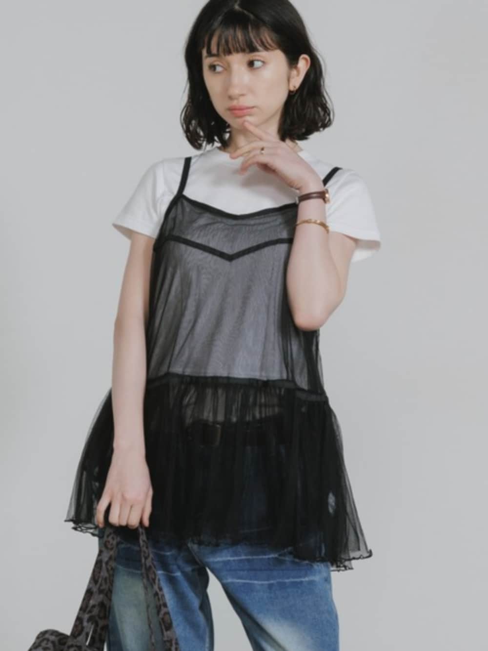 ブルー系のデニムパンツ、ブラック系のワンピース、ホワイト系のTシャツ/カットソーを着用したレディースの春コーディネートの2枚目の写真